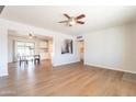 Spacious living area showcasing the wood floors, ceiling fan, and seamless flow into the dining space at 1001 W 19Th St, Tempe, AZ 85281