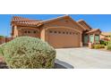 Single-story home featuring a two-car garage with a wide driveway and desert landscaping at 11242 E Onza Ave, Mesa, AZ 85212