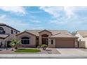 Tan home featuring a tile roof, well-maintained landscaping, and a two-car garage at 1398 W Windhaven Ave, Gilbert, AZ 85233