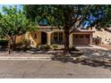 Charming home with mature trees, a front porch, and a two-car garage at 15456 W Corrine Dr, Surprise, AZ 85379