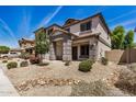 Inviting two-story home features a covered porch, desert landscaping, neutral stucco and stylish grey accents at 16386 W Sierra St, Surprise, AZ 85388