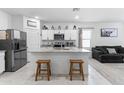 Modern kitchen features white cabinets, stainless steel appliances, and a granite island with seating at 16617 W Desert Mirage Dr, Surprise, AZ 85388