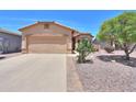 Single-story home featuring a two-car garage, neutral stucco, desert landscaping and a tile roof at 1880 E Birch St, Casa Grande, AZ 85122