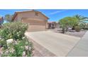 Single-story home featuring a two-car garage, neutral stucco, desert landscaping and a tile roof at 1880 E Birch St, Casa Grande, AZ 85122