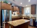 Modern kitchen boasts stainless steel appliances, granite countertops, and custom wood cabinetry at 1898 N Hubbard Ln, Casa Grande, AZ 85122