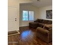 Inviting living room with hardwood floors and a comfortable brown sofa set, bathed in natural light at 1898 N Hubbard Ln, Casa Grande, AZ 85122