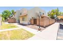 Inviting townhome exterior featuring a lush green lawn, brick wall, and sidewalk at 222 W Brown Rd # 72, Mesa, AZ 85201