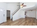 Open-concept living space featuring modern flooring, a staircase, and a ceiling fan at 222 W Brown Rd # 72, Mesa, AZ 85201