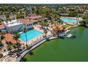 Stunning aerial view of the lakefront community pool with a sandy beach, clubhouse, and lake access at 2301 E Beachcomber Dr, Gilbert, AZ 85234