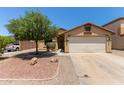 Charming single-story home with low maintenance desert landscaping, two car garage, and mature shade tree at 25060 W Vista Norte St, Buckeye, AZ 85326