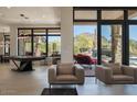 Bright living area with modern furnishings, billiard table, and sliding glass doors with desert views at 26285 N 89Th St, Scottsdale, AZ 85255