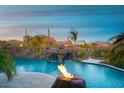 Inviting pool with rock waterfall, fire features, and desert views creating a luxurious outdoor oasis at 26285 N 89Th St, Scottsdale, AZ 85255