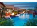 Stunning outdoor living space with a pool, fire feature, covered patio, and lush tropical landscaping at 26285 N 89Th St, Scottsdale, AZ 85255