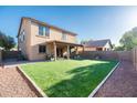 Expansive backyard with artificial turf, a covered patio, and desert landscaping around the perimeter at 2990 E Franklin Ave, Gilbert, AZ 85295