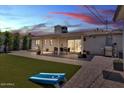Spacious backyard featuring an artificial lawn, covered patio and outdoor dining set at 3505 N Miller Rd, Scottsdale, AZ 85251