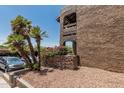 Exterior of stucco condo building with landscaping, bougainvillea, and parking area at 3825 E Camelback Rd # 152, Phoenix, AZ 85018