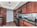 Cozy kitchen with stainless steel appliances, dark granite countertops and wood cabinets at 3825 E Camelback Rd # 152, Phoenix, AZ 85018