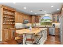 Spacious kitchen featuring a center island with seating, custom cabinetry and stainless steel appliances at 4239 E Azalea Dr, Gilbert, AZ 85298