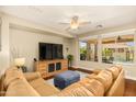Inviting living room with large windows, hardwood floors, a comfortable sectional, and a ceiling fan at 4239 E Azalea Dr, Gilbert, AZ 85298