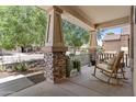 Inviting covered front porch with stone accents and cozy seating at 5303 W Hackamore Dr, Phoenix, AZ 85083