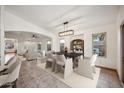Bright dining room featuring a modern chandelier, dining set, and an open-concept layout at 6309 W Hughes Dr, Phoenix, AZ 85043