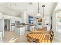 Open-concept kitchen with white cabinetry, granite counters, stainless steel, and a large dining table at 6713 E Paradise Ln, Scottsdale, AZ 85254