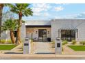 Charming modern home entrance with stylish seating area and beautiful desert landscaping at 7001 E Joan De Arc Ave, Scottsdale, AZ 85254