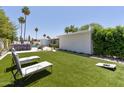 Spacious backyard with manicured lawn, outdoor seating, and mature palm trees creating a serene oasis at 7020 E Friess Dr, Scottsdale, AZ 85254