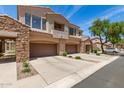 Charming townhome showcasing its garages, desert landscaping, and views of the surrounding neighborhood at 7445 E Eagle Crest Dr # 1111, Mesa, AZ 85207