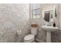 Charming powder room features patterned wallpaper, pedestal sink, and stylish mirror at 754 E Harper St # 102, Gilbert, AZ 85297