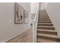 Bright hallway boasts wood-look tile flooring, staircase, and stylish wall art at 754 E Harper St # 102, Gilbert, AZ 85297
