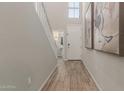 Hallway with wood-look tile leads to powder room; accented with elegant wall art at 754 E Harper St # 102, Gilbert, AZ 85297