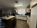 The spacious kitchen features an island, white cabinets, and vinyl floors at 7664 W Vermont Ave, Glendale, AZ 85303
