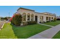 Lovely front exterior with vibrant bougainvillea, arched windows, and neatly trimmed lawn at 8317 E Orange Blossom Ln, Scottsdale, AZ 85250