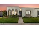 Inviting home front featuring manicured lawn, arched windows, and a secure decorative front door at 8317 E Orange Blossom Ln, Scottsdale, AZ 85250
