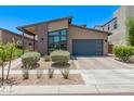Charming home featuring desert landscaping, modern windows, and a gray two-car garage at 939 E Paseo Way, Phoenix, AZ 85042