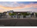 Charming stucco home featuring a tile roof, desert landscaping, and gated driveway at sunset at 10024 N 61St Pl, Paradise Valley, AZ 85253