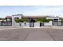 Charming stucco home featuring a tile roof, desert landscaping, and gated driveway at 10024 N 61St Pl, Paradise Valley, AZ 85253