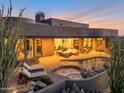 Stunning backyard featuring an outdoor pool, hot tub, patio with outdoor furniture and lush desert landscaping at 10664 E Monument Dr, Scottsdale, AZ 85262