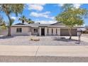 Charming single-story home with a well-maintained gravel yard, mature trees, and a welcoming entrance at 13215 N 30Th Pl, Phoenix, AZ 85032