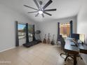 Spacious living area with a ceiling fan, neutral paint, and natural light from two windows at 14728 W Redfield Rd, Surprise, AZ 85379