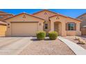Inviting single-story house with a desert landscape, two green bushes, and a convenient two-car garage at 17693 W Lincoln St, Goodyear, AZ 85338