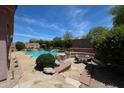 An inviting pool area, featuring a built-in BBQ, seating, and lush landscaping, perfect for outdoor entertaining at 17975 W Willow Dr, Goodyear, AZ 85338