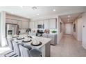 Bright kitchen featuring a large island with granite countertops, stainless steel appliances, and grey cabinets at 18134 W Creedance Blvd, Surprise, AZ 85387