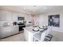 Bright kitchen featuring a large island with granite countertops, stainless steel appliances, and grey cabinets at 18134 W Creedance Blvd, Surprise, AZ 85387
