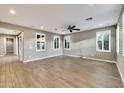 Bright living room with wood tile floors, neutral walls, stylish lighting, and multiple windows with shutters at 18562 N 94Th St, Scottsdale, AZ 85255