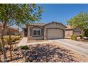 Charming single-story home featuring a two-car garage, desert landscaping, and inviting entryway at 20251 W Madison St, Buckeye, AZ 85326