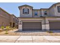 Two-story home featuring a spacious two car garage, stone accents, and a well-maintained paver driveway at 21047 N 58Th Way, Phoenix, AZ 85054