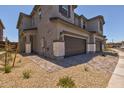 Two-story home showcasing stone accents, a two car garage, and a well-maintained paver walkway at 21047 N 58Th Way, Phoenix, AZ 85054