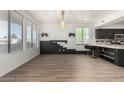 Open living space with plank flooring, contemporary lighting, and large windows for natural light at 21655 N 36Th Ave # 131, Glendale, AZ 85308